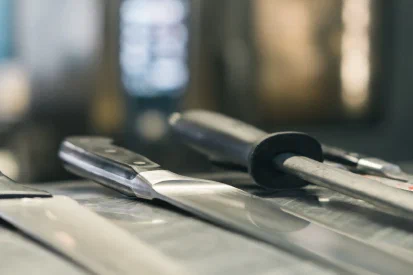 Een aantal koksmessen op een rij op een werkblad