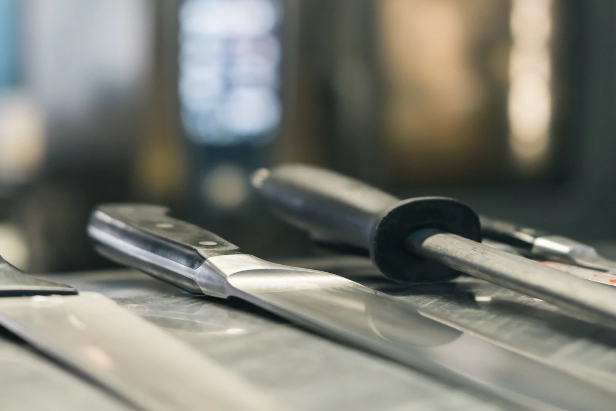 Een aantal koksmessen op een rij op een werkblad