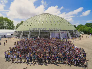 The Super Bock Arena in Porto, a large dome shaped event hall, with some 1,000 posing in front of it